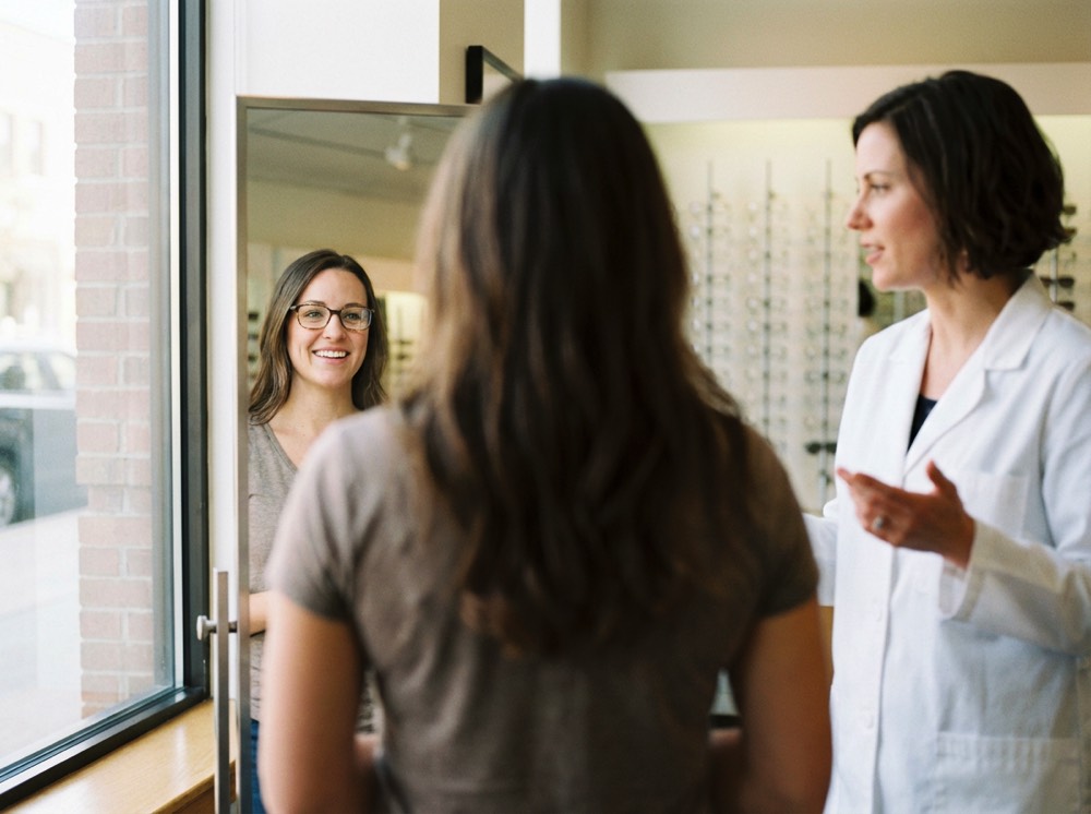 Cliente soddisfatto che parla con l’ottico al banco SEL Optical.